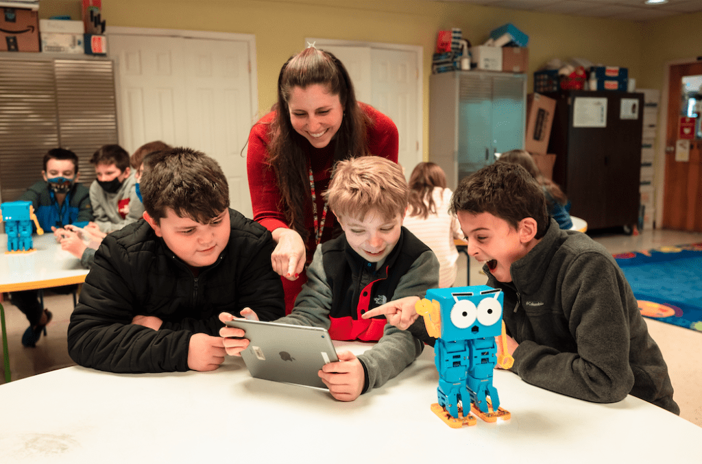 A teacher with three students and Marty the Robot